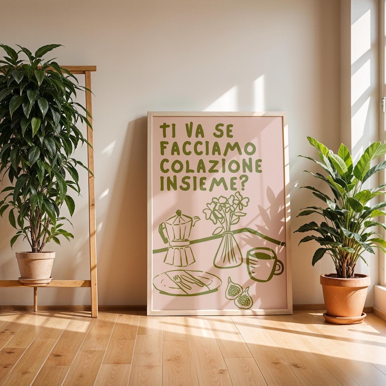 May include: A pink and green illustrated poster with the text "Ti va se facciamo colazione insieme?"  The poster depicts a coffee pot, a plate with cutlery, a vase of flowers, and a cup of coffee.