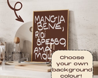 May include: A framed print with the text "Mangia Bene, Riidi Spesso, Ama Molt" in white on a brown background. The print is sitting on a counter with other kitchen items.