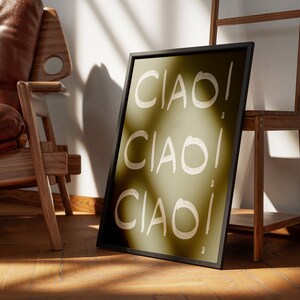 May include: A framed print with a green background and the word "CIAO!" written three times in white. The print is leaning against a wooden ladder.