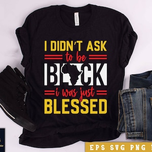 May include: Black t-shirt with a yellow and red graphic that says "I didn't ask to be black, I was just blessed". The graphic also includes a red outline of the continent of Africa.