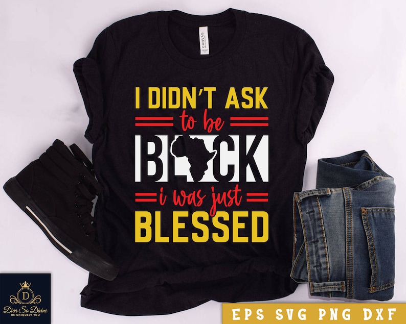 May include: Black t-shirt with a yellow and red graphic that says "I didn't ask to be black, I was just blessed". The graphic also includes a red outline of the continent of Africa.