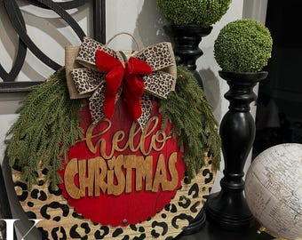 Okrągły wieszak na drzwi Hello Christmas o średnicy 18 cali. Czarny gepard z czerwonym akcentem.