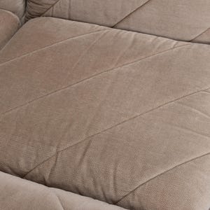 May include: A beige sofa cushion featuring a textured fabric surface with a prominent diagonal stitched pattern. The cushion is square-shaped with visible seams that create a geometric grid across the upholstery, showcasing a neutral tone.