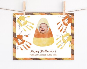 Puede incluir: Una tarjeta de Halloween con la cara de un bebé dentro de una ilustración de caramelo de maíz. La tarjeta tiene un fondo blanco con detalles en naranja, amarillo y marrón. El texto dice "Happy Halloween! From your little candy corn."
