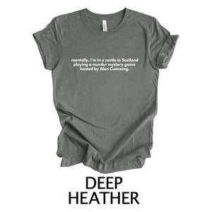 May include: A dark heather grey t-shirt with the text "mentally, I'm in a castle in Scotland playing a murder mystery game hosted by Alan Cumming."