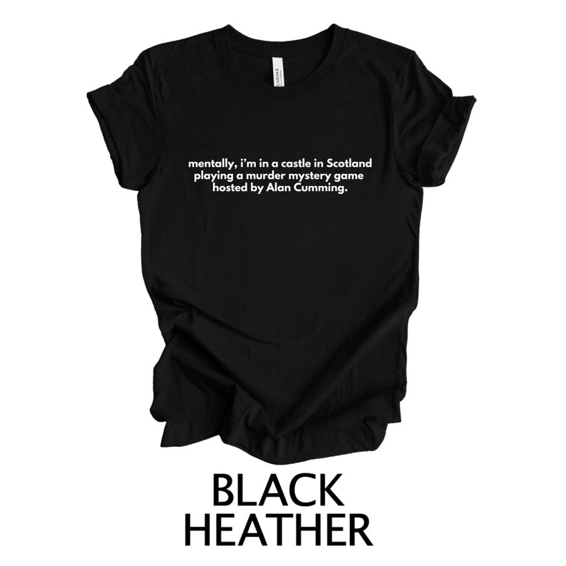 May include: Black heather t-shirt with white text that reads "mentally, I'm in a castle in Scotland playing a murder mystery game hosted by Alan Cumming."