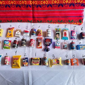 May include: A collection of miniature food and beverage cans and boxes, arranged in alphabetical order from A to Z, then 1 to 6. The items are mostly in red, blue, and yellow colors. Some of the items have text on them, such as "Ariel", "Suavel", "Nito", "Foga", "Zo", and "Lice".