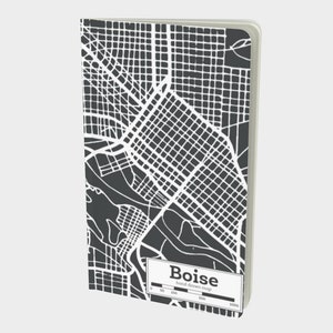 May include: A black and white hand-drawn map of Boise, Idaho. The map is printed on a notebook cover. The scale of the map is shown in feet.