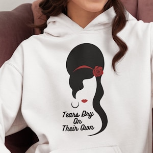 May include: White hoodie with a black and red graphic of a woman with a beehive hairstyle and a red rose. The text "Tears Dry On Their Own" is printed below the graphic.