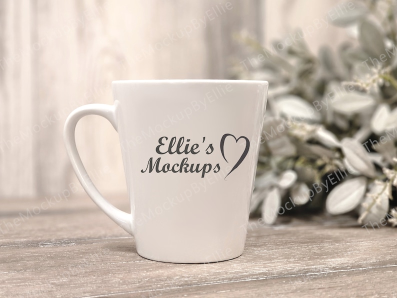 Może przedstawiać: Biały kubek ceramiczny z czarnym sercem i tekstem "Ellie's Mockups" na boku.