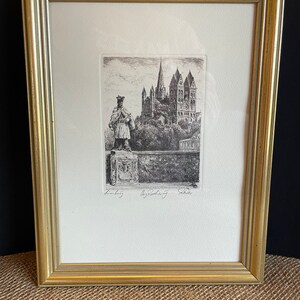 Könnte beinhalten: Eine Schwarzweiß-Radierung einer Kirche mit einer Figur, die davor steht. Die Radierung ist in einem goldenen Rahmen gerahmt und unten rechts mit "Lindeburg" und "G. Roderich" signiert.