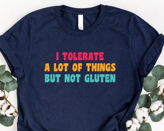 May include: A navy blue t-shirt with the text "I tolerate a lot of things but not gluten" in colorful letters.