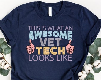 May include: Navy blue t-shirt with the text "This is what an awesome vet tech looks like" in colorful letters with thumbs up on either side of the text.
