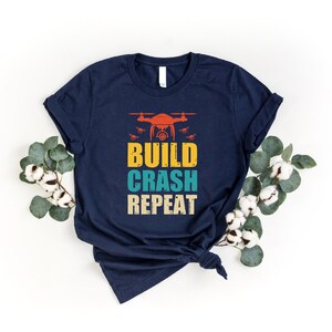a t - shirt with the words build crash repeat on it
