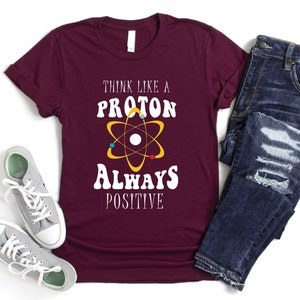 a t - shirt that says think like a proton always positive