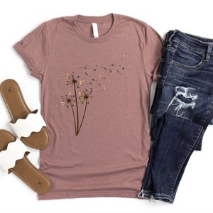 a t - shirt with a dandelion on it next to a pair of