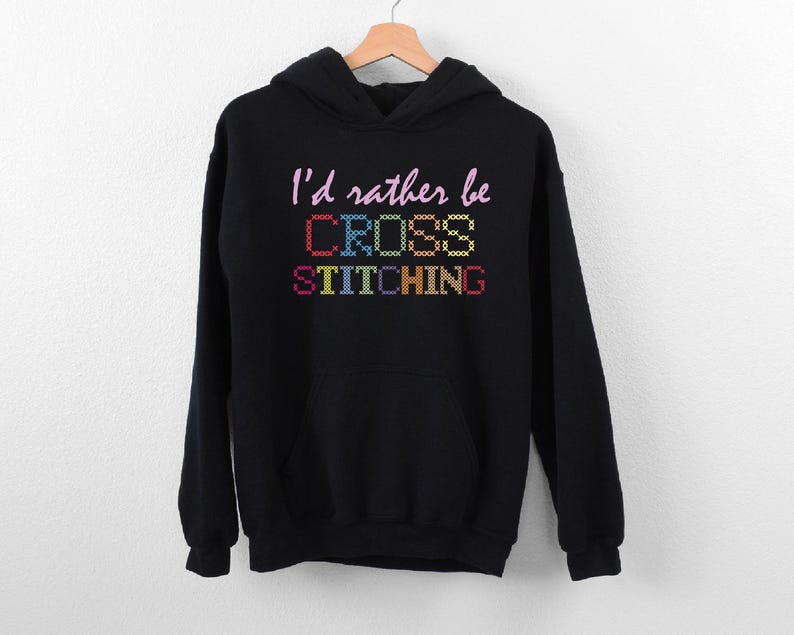 a black sweatshirt with the words i'd rather be cross stitching on it