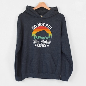 a dark blue sweatshirt with the words do not pet the ugly cows on it