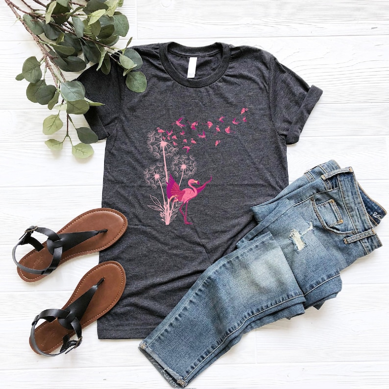 a t - shirt with a pink flamingo on it next to a pair of
