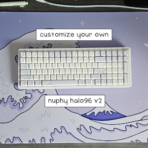 May include: A white Nuphy Halo96 v2 mechanical keyboard with white keycaps rests on a custom mousepad. The mousepad features a wave design in shades of purple and blue, with the text "customize your own".