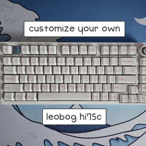 May include: A white mechanical keyboard with white keycaps and light pink lettering. The keyboard features a rotary knob in the top right corner and a blue accent key. Text above and below the keyboard reads "customize your own" and "leobog hi75c".