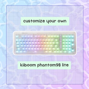 May include: A white keyboard with rainbow-colored backlit keys. The keyboard has a rectangular shape and features the text "customize your own" and "kiiboom phantom98 lite". The keys are arranged in a standard QWERTY layout.
