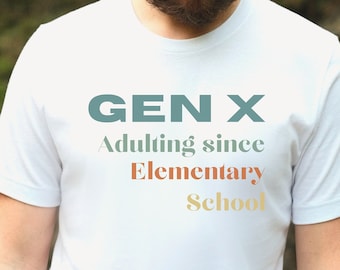 May include: White t-shirt with the text "GEN X Adulting since Elementary School" in teal, red, and yellow. The shirt is worn by a person with a beard, against a blurred green background.