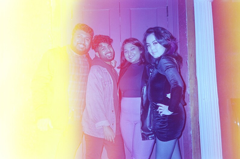 Puede incluir: Foto de cuatro personas sonriendo. La imagen tiene un degradado amarillo y morado. Una persona lleva una chaqueta vaquera y otra un vestido negro. El grupo incluye dos hombres y dos mujeres.