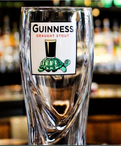 GUINNESS DRAUGHT 6.5 BEER GLASS WITH SEAL BALANCING A BEER ON IT'S NOSE