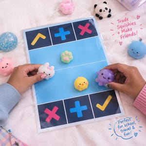 Könnte beinhalten: Ein laminiertes Spielbrett mit dunkelblauen und hellblauen Abschnitten, das Symbole wie Pluszeichen, Häkchen und X-Markierungen zeigt. Kleine, bunte Silikon-Squishy-Spielzeuge in Form von Tieren und einer Pfote liegen auf dem Brett mit Text.