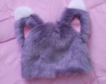 May include: Purple faux fur cat ear hat with white tips and pink inner ears.