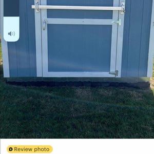 Puede incluir: Una puerta de cobertizo azul con un marco blanco y una barra de seguridad plateada. La puerta del cobertizo tiene un letrero blanco que dice "Tuff Shed".