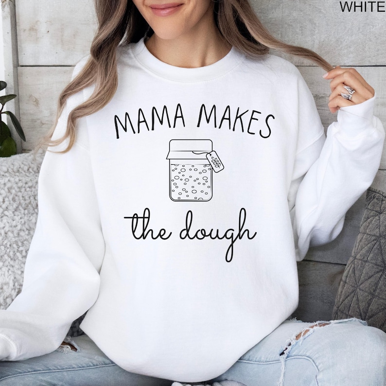May include: White sweatshirt with the text "Mama Makes the Dough" and a drawing of a jar with a label that says "Starter" on it.