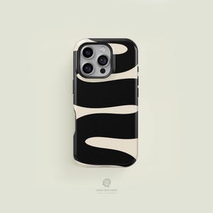 Puede incluir: Una funda de teléfono negra y crema con un patrón ondulado. La funda tiene un borde negro y un recorte para la cámara. El diseño presenta un patrón repetitivo de líneas curvas negras y crema. Las palabras "CASE FACE CASES" están impresas en la parte inferior.