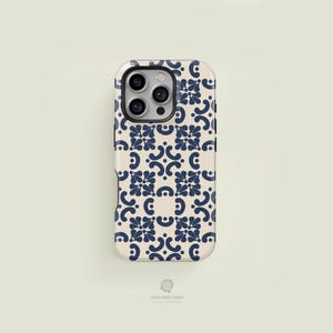 May include: A phone case with a cream background and a repeating navy blue floral pattern. The case has a camera cutout and the text "CASE FACE CASES" at the bottom.