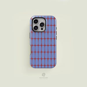 以下が含まれることがあります： 青と赤の幾何学模様のスマートフォンケース。ケースは角が丸い長方形のデザインで、カメラの切り抜きがあります。パターンは、青い背景に赤い縦長の長方形で構成されています。「CASE FACE CASES」のブランド名が下部に印刷されています。