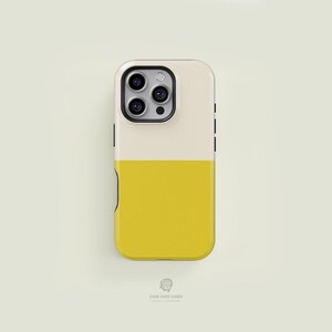 Puede incluir: Funda de teléfono de dos tonos con una mitad superior color crema y una mitad inferior de color amarillo brillante. La funda tiene un recorte para la cámara y botones laterales negros. La marca "CASE FACE CASES" está impresa en la parte inferior.