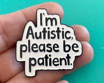 May include: White enamel pin with black text that reads "I'm Autistic, please be patient."