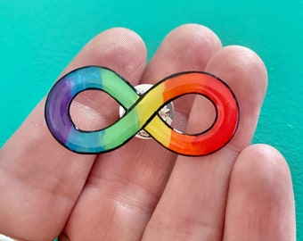 May include: A rainbow infinity symbol pin. The pin is made of metal and has a rainbow enamel finish. The infinity symbol is a popular symbol of love, friendship, and eternity.