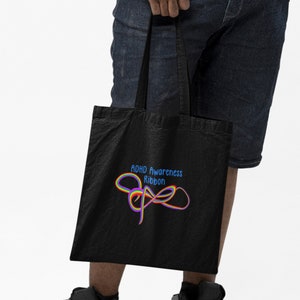 May include: Black tote bag with a rainbow ribbon design and the text "ADHD Awareness Ribbon".