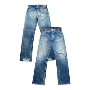 以下が含まれることがあります： ヴィンテージの青いデニムジーンズが2足。1足は後ろから表示され、ポケットとベルトループが見えます。もう1足は前から表示され、膝が破れていて、色あせたウォッシュ加工が施されています。どちらのペアもクラシックなストレートレッグフィットです。