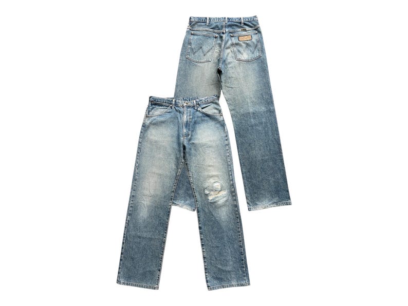 K&ouml;nnte beinhalten: Zwei Jeanshosen aus hellblauem Denim. Eine Hose ist mit dem R&uuml;cken zum Betrachter positioniert und zeigt die Ges&auml;&szlig;taschen und G&uuml;rtelschlaufen. Die andere Hose befindet sich davor und hat ein abgenutztes Knie. Beide Hosen haben eine klassische, gerade Passform.