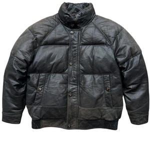 May include: A black leather puffer jacket with a high collar and button-up front. The jacket has two front pockets and a ribbed hem. The leather appears worn, giving it a vintage look. A classic outerwear piece.