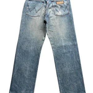 K&ouml;nnte beinhalten: Hellblaue Jeans mit klassischem F&uuml;nf-Taschen-Design. Die Ges&auml;&szlig;taschen haben eine 'W'-Naht. Ein braunes Lederetikett mit Markenname ist sichtbar. Die Jeans hat eine verwaschene Optik und einen geraden Beinverlauf.