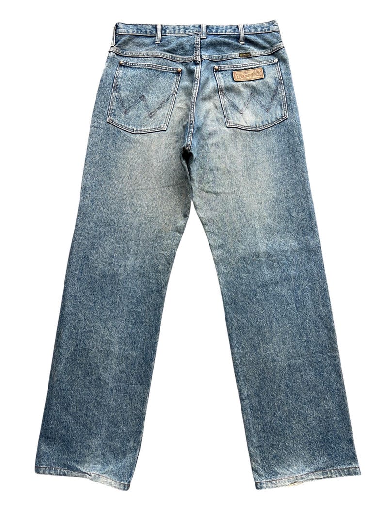K&ouml;nnte beinhalten: Hellblaue Jeans mit klassischem F&uuml;nf-Taschen-Design. Die Ges&auml;&szlig;taschen haben eine 'W'-Naht. Ein braunes Lederetikett mit Markenname ist sichtbar. Die Jeans hat eine verwaschene Optik und einen geraden Beinverlauf.