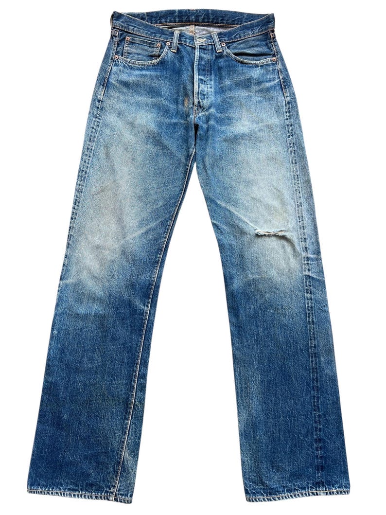 以下が含まれることがあります： ボタンフライとダメージ加工の膝が特徴の、色あせたブルーデニムジーンズ。 ジーンズは、クラシックな5ポケットデザインとストレートレッグフィットです。 デニムは使い古された外観をしています。
