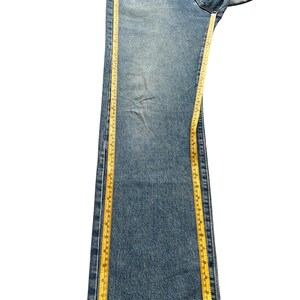 K&ouml;nnte beinhalten: Hellblaue Jeans mit geradem Bein. Ein gelbes Ma&szlig;band wird entlang der Jeans platziert. Die Jeans ist etwa 102 cm lang.