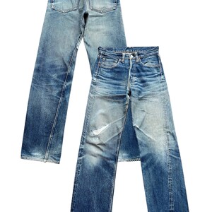 Pu&ograve; includere: Due paia di jeans vintage in denim blu. Un paio &egrave; visto da dietro, mostrando le tasche e la cintura. L'altro paio &egrave; davanti, mostrando le tasche anteriori, la chiusura con bottoni e i dettagli usurati. I jeans hanno un aspetto sbiadito e usurato.