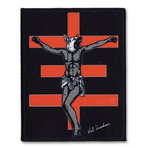 May include: Black and red patch with a stylized image of a person with a dog's head on a cross. The image is in a black and white style. The text "Val Dufour" is in the bottom right corner.
