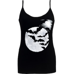 May include: Black camisole top with thin straps. The front features a white graphic of bats flying in front of a full moon. A spooky and stylish top for Halloween or gothic-themed outfits.